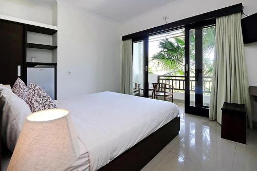 a bedroom with a large bed and a large window at Indah Homestay in Seminyak