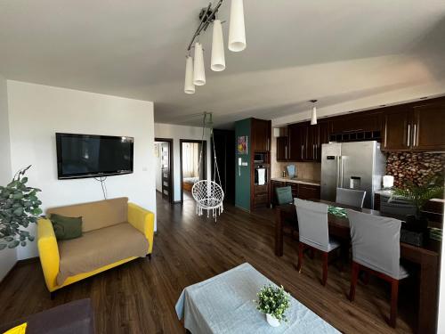 a living room with a couch and a kitchen at Cora Lego Apartment City View near Stadium & Sinfonia Varsovia Optional Parking in Warsaw