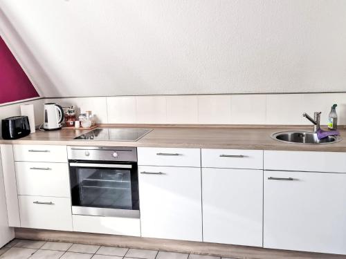 a kitchen with white cabinets and a sink at Apartment Workbase Nidderau by Interhome in Nidderau