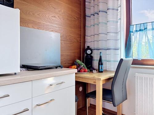 a kitchen with a desk with a laptop and a chair at Studio Sirch-1 by Interhome in Diedorf