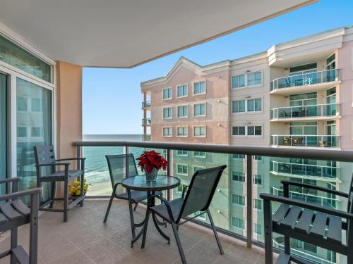 a balcony with a table and chairs and a view of the ocean at Oceanfront Get Away in Myrtle Beach