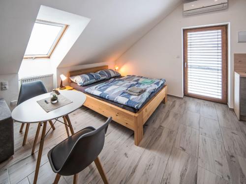 a bedroom with a bed and a table and chairs at Studio V Šachu-4 by Interhome in Dačice