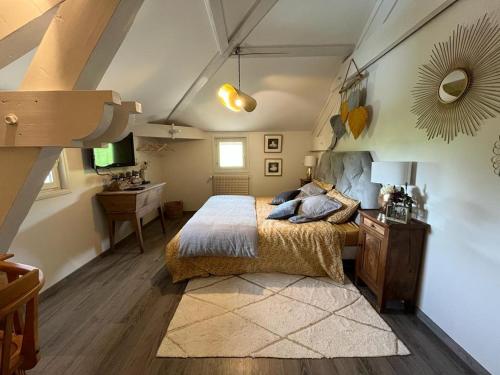 a bedroom with a bed and a desk in it at Les CHAMBRES des EAUX in Sarcey