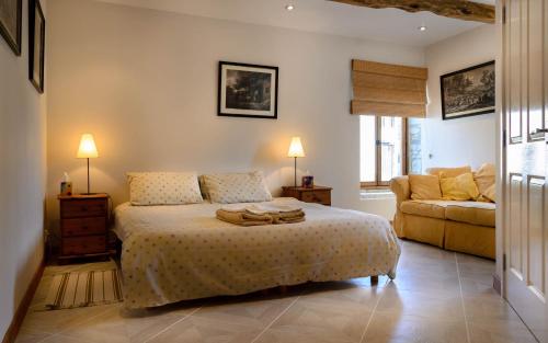 a bedroom with a bed and a couch at Gites Arches de Muschamp in Cussay