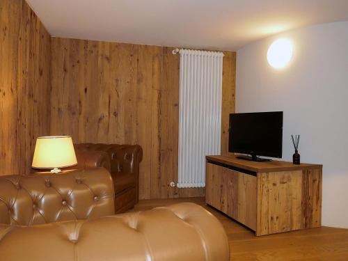 a living room with a couch and a television at Apartment Rina by Interhome in Olivone