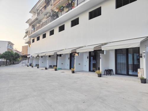 a large white building with a row of windows at CORFU INDUSTRIAL Studios in Corfu