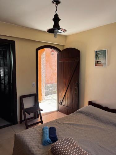 a bedroom with a bed and a door with a chair at Encanto da Serra 2 in Miguel Pereira