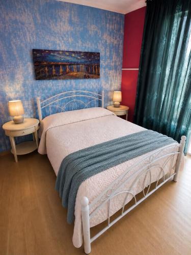 a bedroom with a bed with blue and red walls at Sea & Sun Grigoleti in Grigoleti