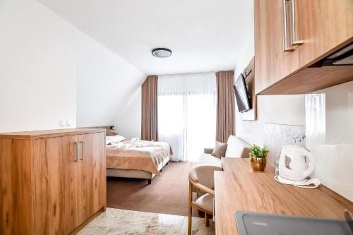 a hotel room with a bedroom and a bed at Cichowiański Folk & Prestige in Poronin
