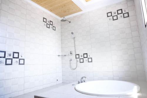 a white bathroom with a tub and a shower at 富晴汽車旅館Fu Ching Motel in Changhua City