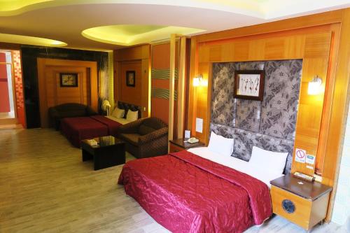 彰化市にある富晴汽車旅館Fu Ching Motelのベッドとリビングルームが備わるホテルルームです。