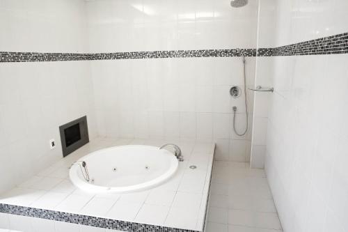 a white bathroom with a tub and a shower at 富晴汽車旅館Fu Ching Motel in Changhua City