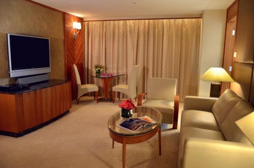a living room with a couch and a television at Grandview Hotel Macau in Macau