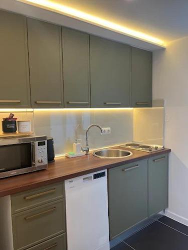 a kitchen with a sink and a microwave at Apartman Kvesić in Široki Brijeg