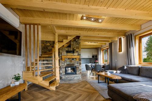 a living room with a staircase and a stone fireplace at Kamienny Horyzont in Bereżnica Wyżna