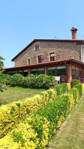 a large brick house with flowers in front of it at Posada Herrán in Santillana del Mar