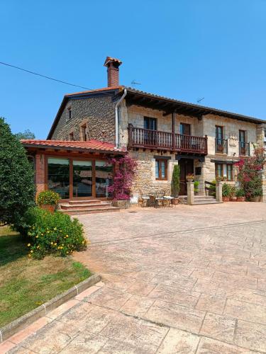 a large brick building with a patio in front of it at Posada Herrán in Santillana del Mar