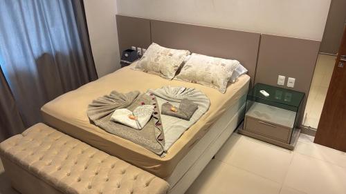 a bedroom with a bed with two blankets and a chair at Espaço MGS in Foz do Iguaçu