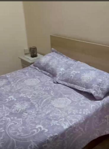 a bed with a blue comforter and pillows on it at Shivram guest house in Plaine Magnien