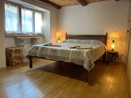 a bedroom with a large bed with two lamps on it at Pancuc Charme & Relax in Gordevio