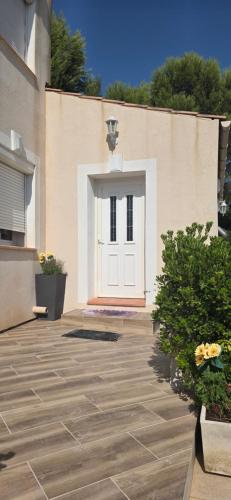 a white door on the side of a building at Maison rénovée avec terasse et jardin privé, aéroport et Aix-en-Provence à 15 minutes in Velaux