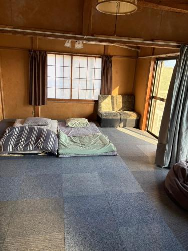 two beds in a room with two windows at 海っぺりー作田 in Katakai