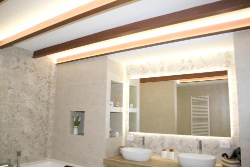 a bathroom with two sinks and a large mirror at Antica Stella in Specchia
