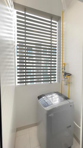 a white bathroom with a window and a water tank at Premium 2BHK Modern Design in Muscat