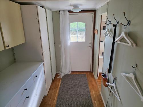 a room with a hallway with a door and a rug at Smaland Trollsjö in Mönsterås