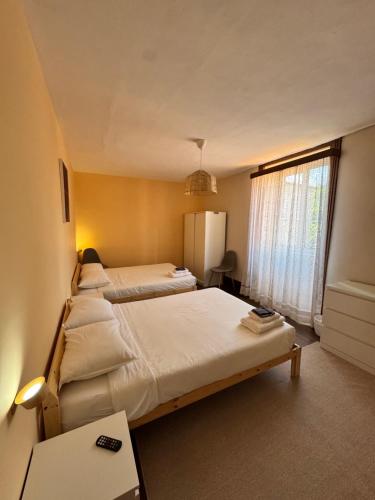 a bedroom with two beds and a window at Miquinhas Norte in Freamunde