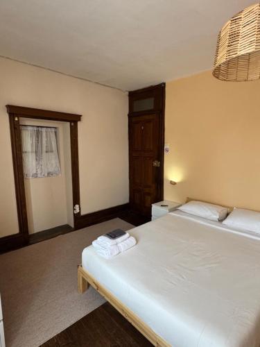 a bedroom with two beds and a door with a window at Miquinhas Norte in Freamunde
