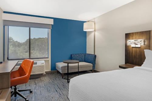 a hotel room with a bed and a desk and a chair at Holiday Inn Express Hyannis - Cape Cod by IHG in Hyannis