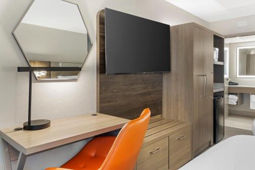a room with a desk with a tv and a chair at Holiday Inn Express Hyannis - Cape Cod by IHG in Hyannis