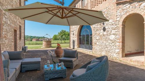 a patio with two chairs and an umbrella at ALBORATA 10, Emma Villas in San Giovanni dʼAsso