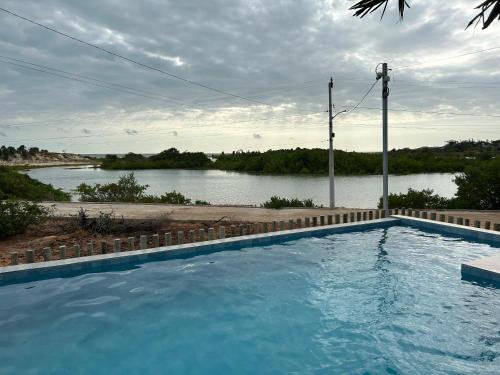 a large swimming pool with a view of a river at Chalé Anjos Mar in Barrinha