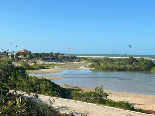 a river with birds flying over a beach at Chalé Anjos Mar in Barrinha
