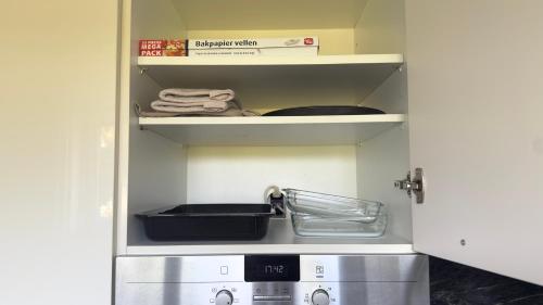 a kitchen with a stove and a shelf with a box at Basel Haven in Münchenstein