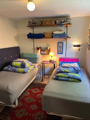 a room with two beds and a couch and a table at Genbrugsfabrikkens Tiny apartment in Holbæk