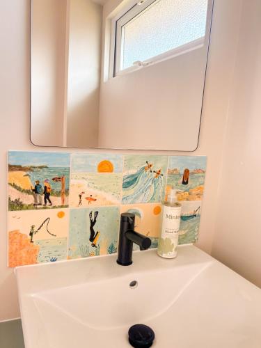 a bathroom with a sink and a mirror at The Coastal Cosy, St Merryn, Padstow in Saint Merryn