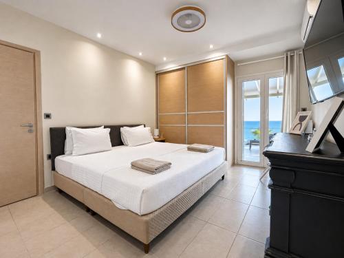 a bedroom with a large bed and a television at Infinity Beach House by KLV in Argostoli