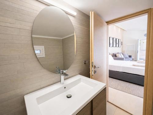 a bathroom with a sink and a mirror and a bed at Infinity Beach House by KLV in Argostoli