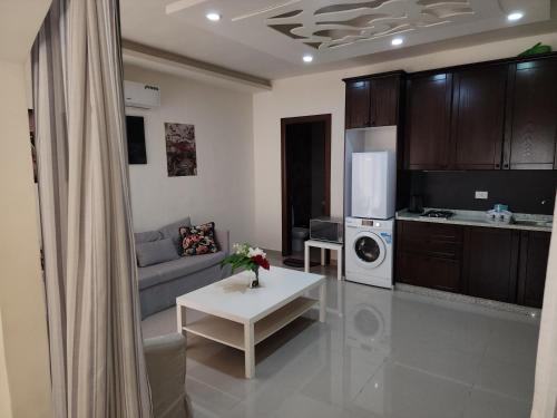 a living room with a couch and a kitchen at Al-Amaari Gardens Compound 3092 in Irbid