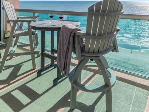 a rocking chair and a table with two glasses of wine at Crescent Beauty in Myrtle Beach