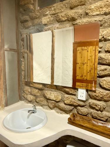 a stone bathroom with a sink and a mirror at Hotel Puerto Antiguo in Los Órganos