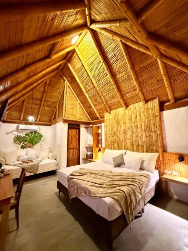 a bedroom with a large bed in a room with wooden ceilings at Hotel Puerto Antiguo in Los Órganos