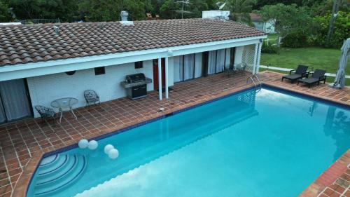 a swimming pool with a patio and a house at La Finca in Miami