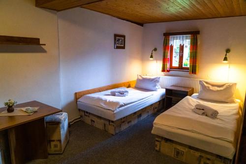 a room with two beds and a table and a window at Pension Skalicky in Pec pod Sněžkou