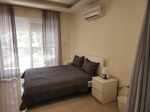 a small bedroom with a bed and a window at Al-Amaari Gardens Compound 3092 in Irbid