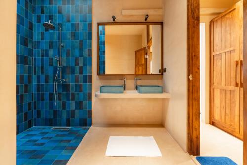 a bathroom with a sink and a shower with a mirror at Tombolo Bay in Dickwella
