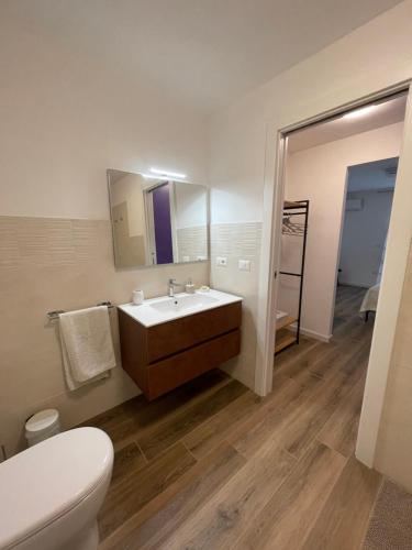 a bathroom with a sink and a toilet and a mirror at Casa natura in Usini